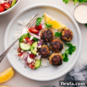 Taverna-Style Greek Turkey Meatballs 3 Close-up of baked Greek Turkey Meatballs served with creamy feta sauce, garnished with fresh herbs.