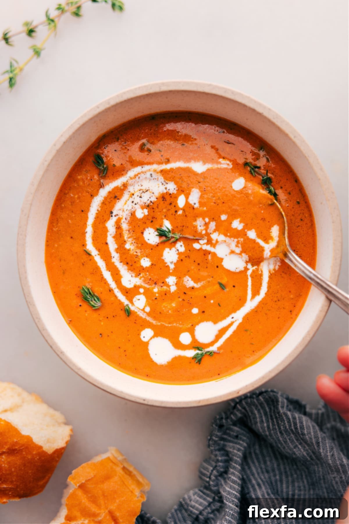 A large, inviting bowl of creamy Roasted Red Pepper Soup, garnished with a swirl of basil pesto and fresh herbs, ready to be enjoyed.