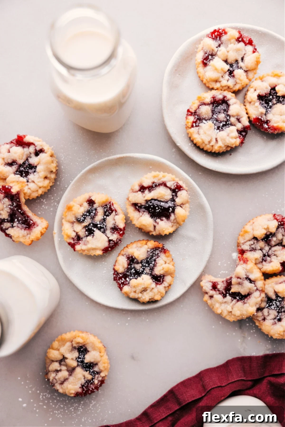 Costco's Raspberry Crumble Cookies spread out on some plates, showcasing their golden crumb and jam filling.