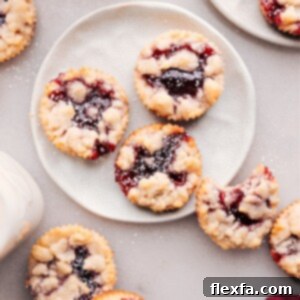 A close-up of a freshly baked Costco Raspberry Crumble Cookie, showing the crumbly topping and the vibrant red jam filling.