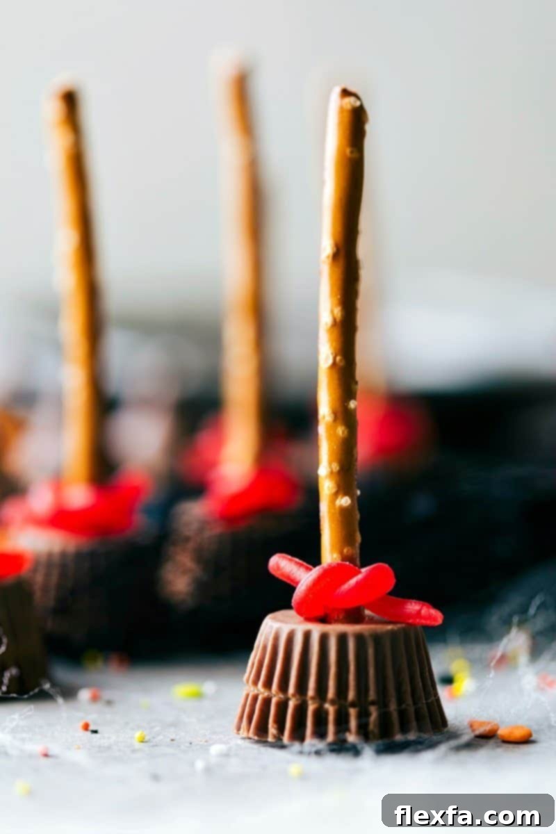 A charming close-up image of a Witch's Broom Halloween treat, made with a Reese's cup and pretzel stick.
