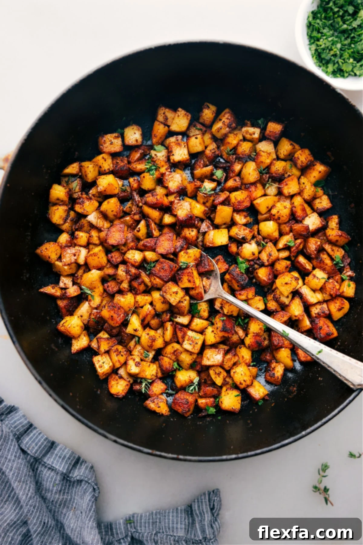A serving of freshly cooked Skillet Breakfast Potatoes garnished with fresh herbs, ready for enjoyment.