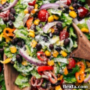 Mexican Salad being tossed with the dressing in a large bowl, ready to be served.