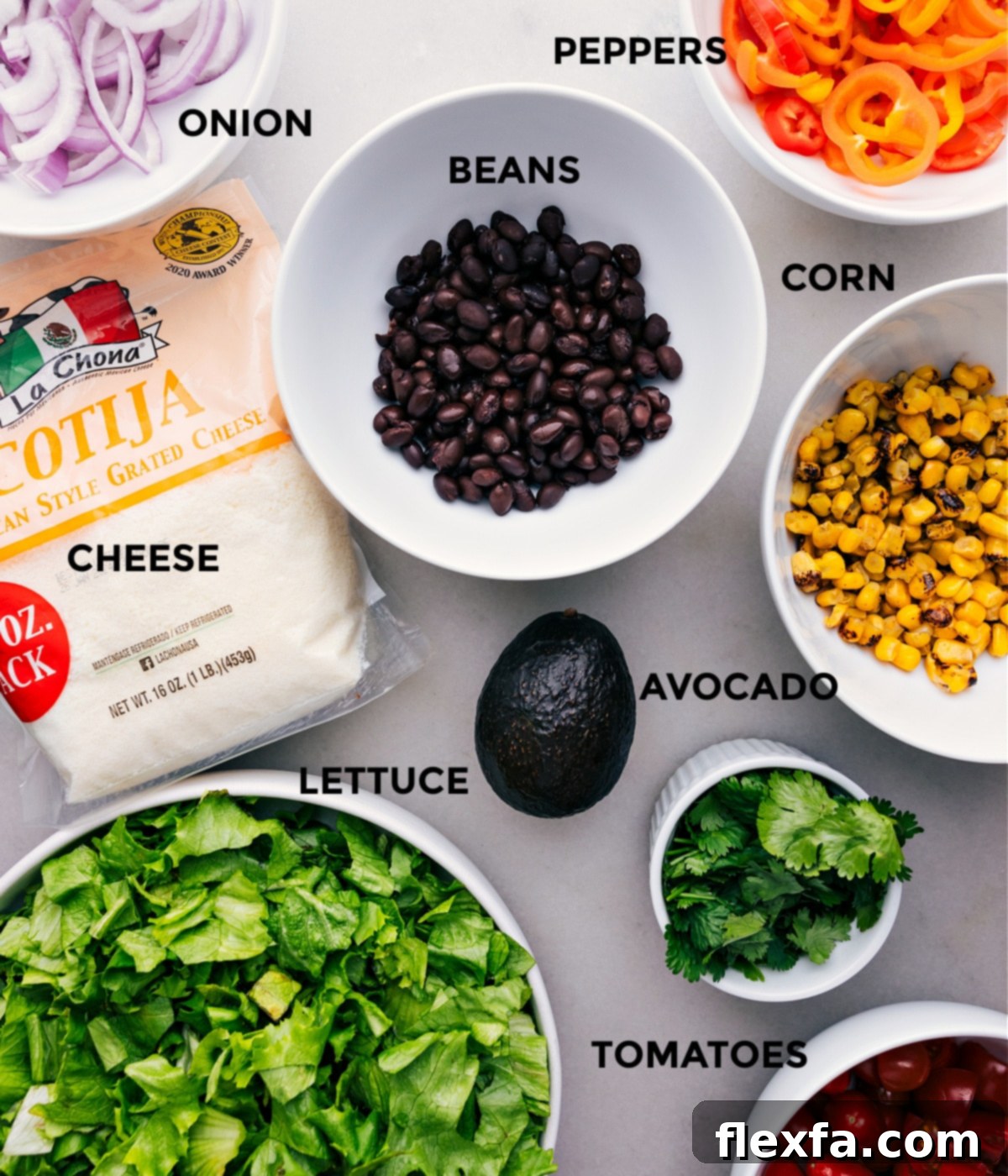 Our Favorite Mexican Salad Ingredients All the fresh ingredients for the Mexican Salad, including chopped romaine, cherry tomatoes, corn, black beans, sweet peppers, and avocado, meticulously prepped and laid out for easy assembly.
