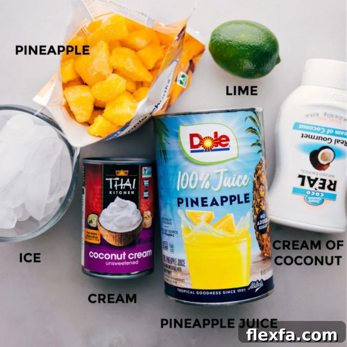 Pina Colada Ingredients Layed Out All the fresh ingredients required for a homemade Pina Colada, including frozen pineapple, cream of coconut, heavy cream, pineapple juice, and lime, neatly prepped on a counter.
