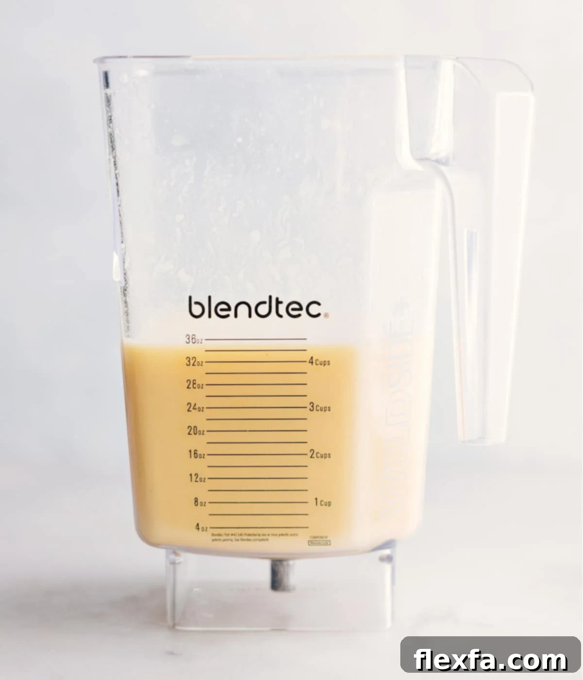 Freshly Blended Pina Colada Drink A vibrant, freshly blended Pina Colada in a glass, ready to be poured and enjoyed.