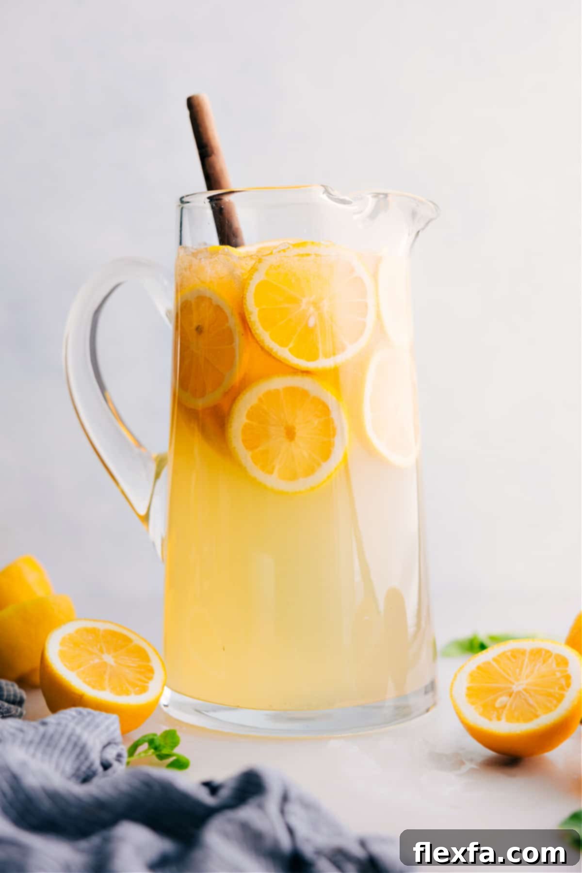 Freshly squeezed lemonade in a glass pitcher with sliced lemons and ice, ready to serve.