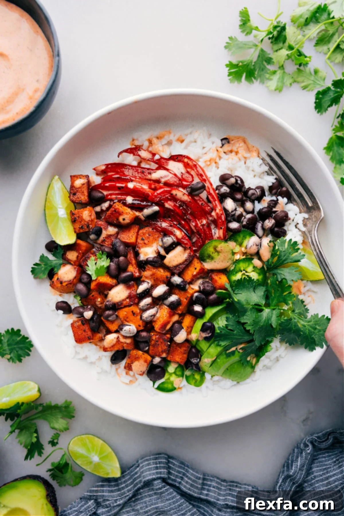 Delicious Sweet Potato and Black Bean Burrito Bowls Sweet Potato and Black Bean Burrito Bowls with dressing drizzled over it.