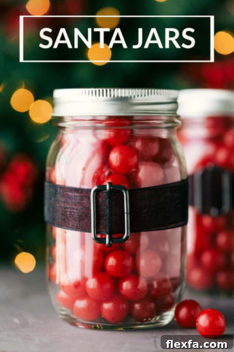 Close-up of Santa Claus themed mason jars, filled with red candies and decorated with black ribbon belts and gold buckles, ideal for Christmas gifts.