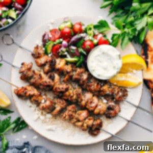 Greek Chicken Bowls on a plate with an easy greek salad, tzatziki dressing, all over rice.
