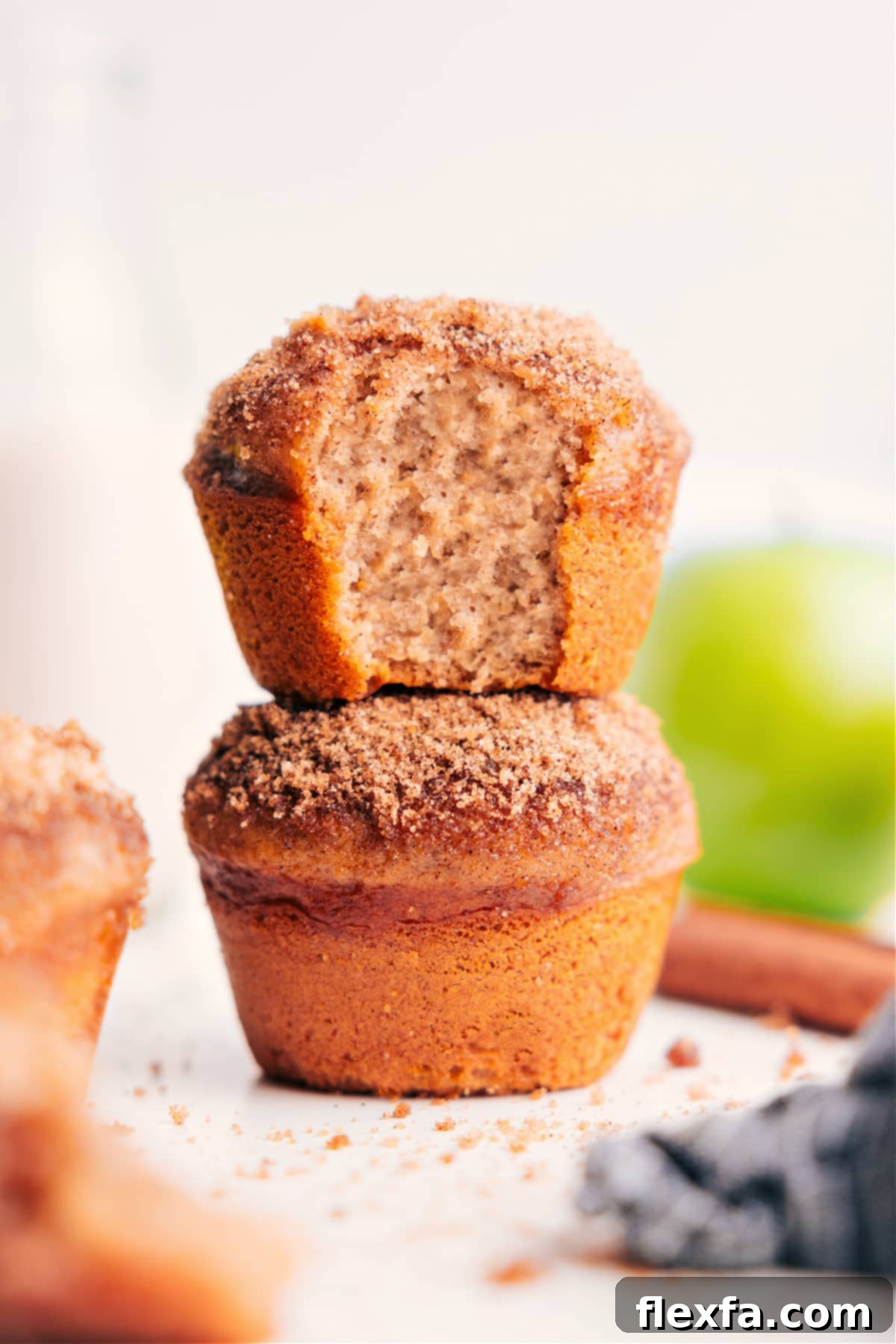 Close-up of fluffy applesauce muffins with a cinnamon-sugar topping on a cooling rack.