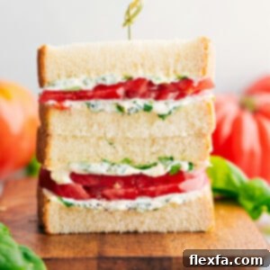 Tomato Sandwich stacked on top of each other showing the delicious inside with vibrant red tomatoes and green basil mayo.