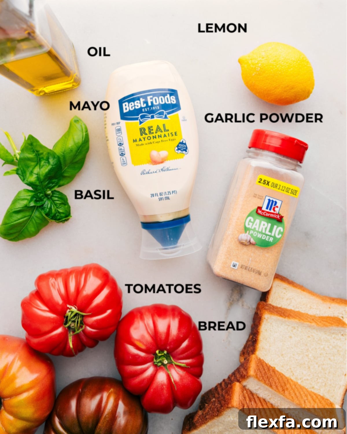 All the ingredients in this recipe prepped out for easy assembly, including fresh basil, ripe tomatoes, and mayonnaise.
