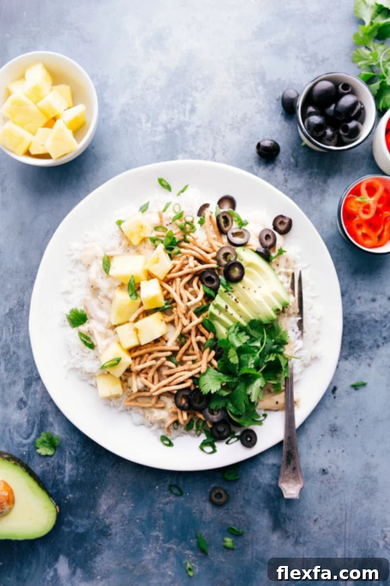 Hawaiian Haystacks: A Feast of Creamy Chicken and Customizable Toppings A vibrant plate of Hawaiian Haystacks overflowing with colorful salad bar toppings like pineapple, olives, and noodles, surrounded by additional ingredients for customization.
