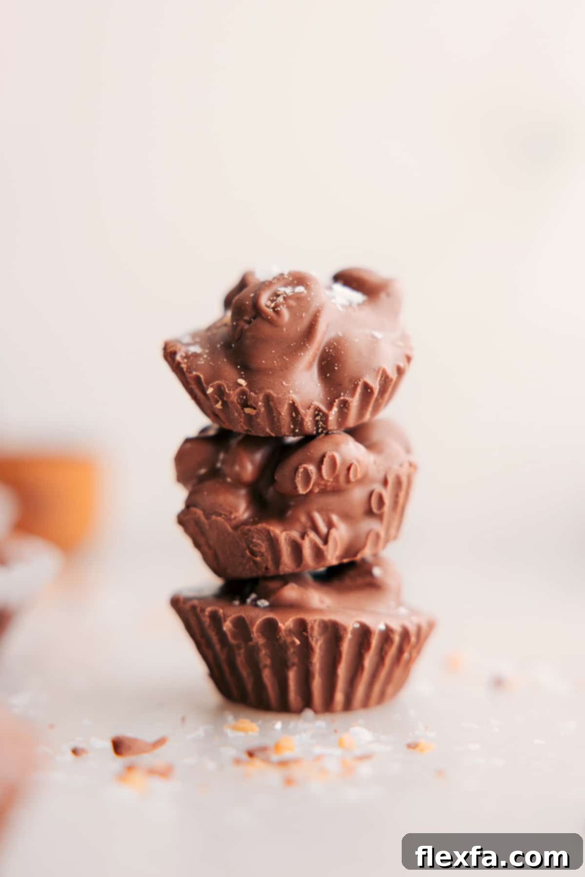 Stacked Crockpot Candy clusters, showcasing their rich chocolate coating and visible peanut texture, ready to be enjoyed.