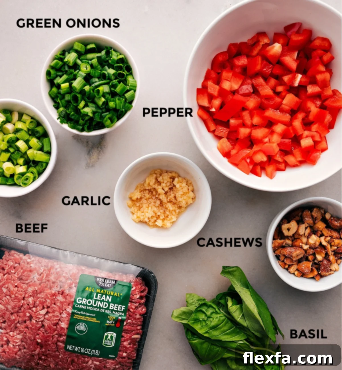Essential Ingredients for Asian Ground Beef All the fresh ingredients for Asian Ground Beef, including colorful peppers, aromatic garlic, lean ground beef, crunchy cashews, and fragrant basil, neatly prepped and ready for cooking.