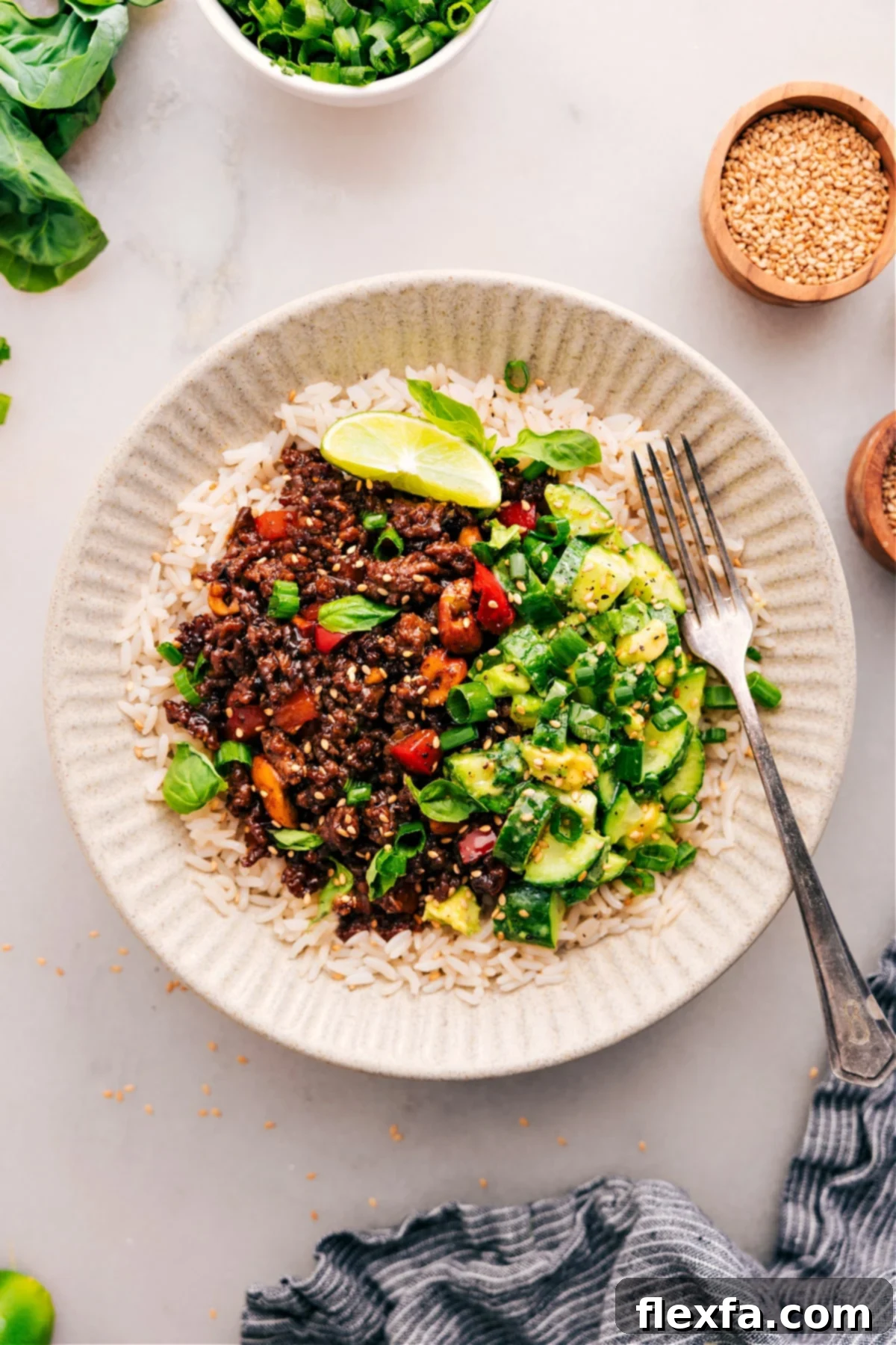 Asian Ground Beef on Rice with a Cucumber Salad The complete Asian ground beef dish, beautifully plated on a bed of fluffy rice, with a refreshing cucumber and avocado salad served elegantly on the side.