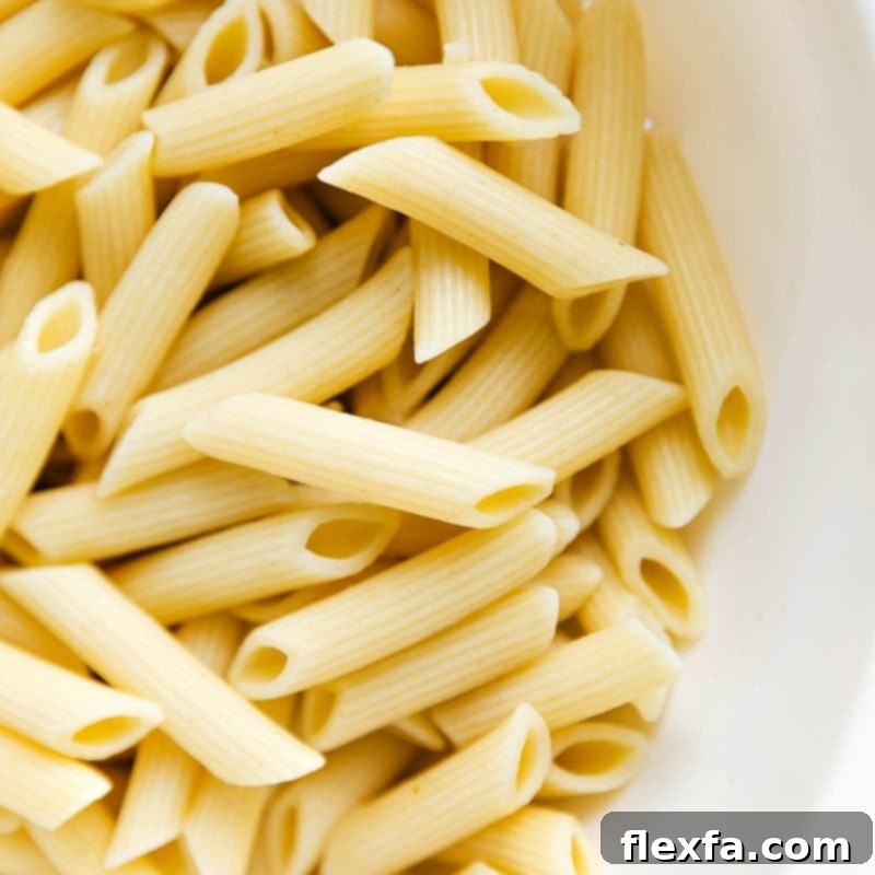 Cooked penne noodles prepared and ready to be combined with the flavorful sauce.