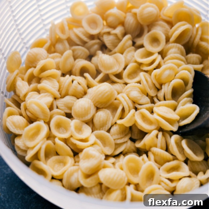 Process shot of perfectly cooked orecchiette pasta, drained and ready to be combined with the savory sausage and broccoli sauce.