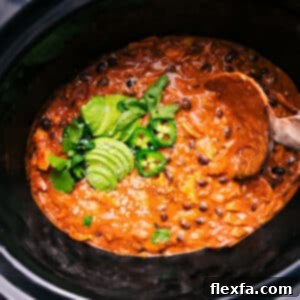 Crockpot Chicken Enchilada Casserole dish topped with fresh cilantro and sour cream.