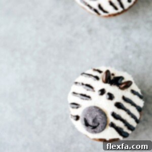EASY JUNGLE CUPCAKES! A beautifully decorated zebra cupcake with black and white stripes, M&M ears, and a cute candy melt face, via chelseasmessyapron.com