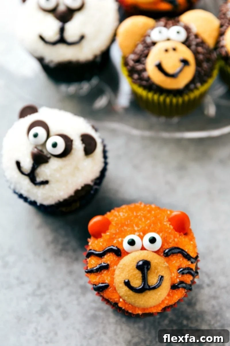 EASY JUNGLE CUPCAKES! A vibrant tiger cupcake with bright orange sparkling sugar, candy eyes, and black gel stripes, perfect for a jungle party, from chelseasmessyapron.com