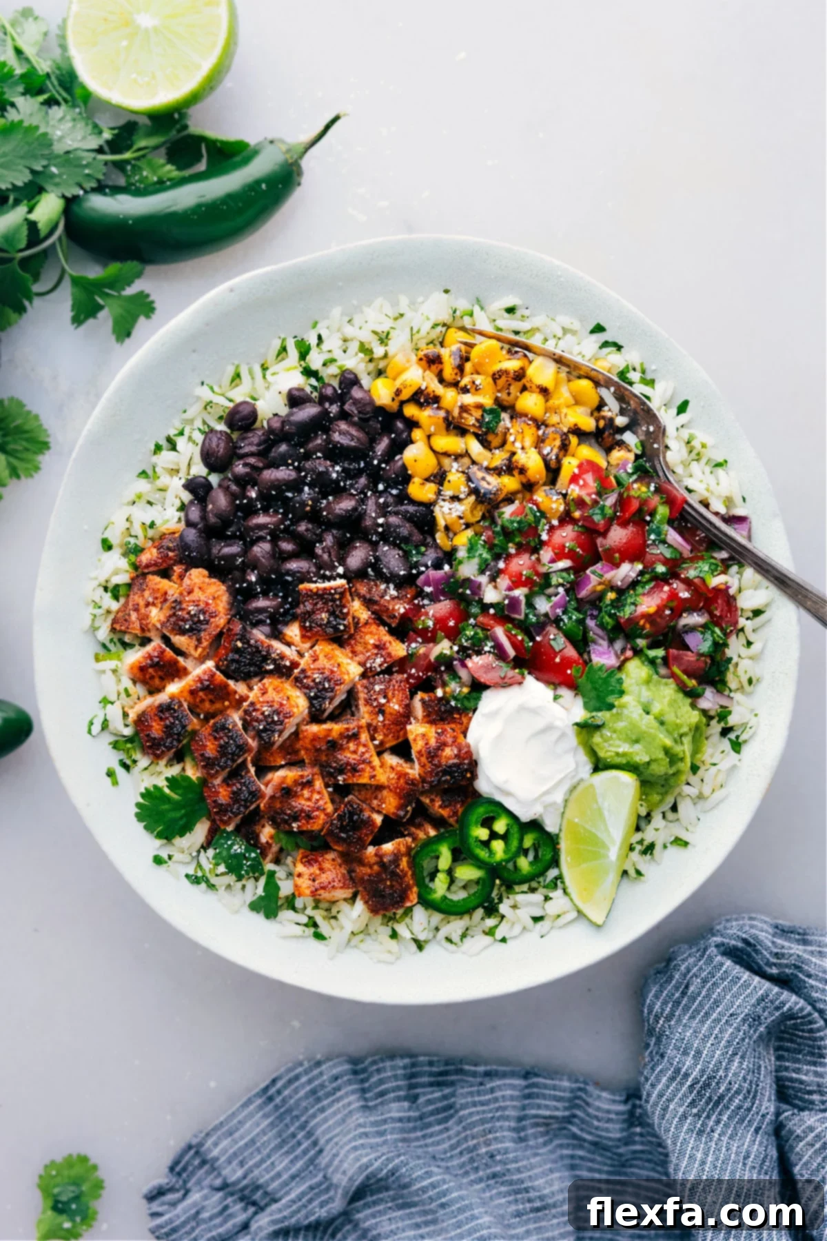 Chicken Burrito Bowls freshly made, garnished with fresh cilantro, lime wedges, and a drizzle of sauce.