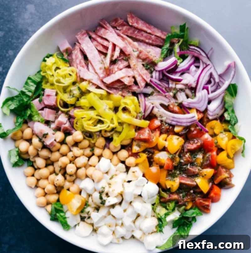 Salami, vegetables, and garbanzo beans layered over crisp lettuce.