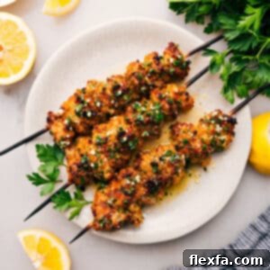 Crispy Chicken Spiedini on skewers with lemon slices and parsley.