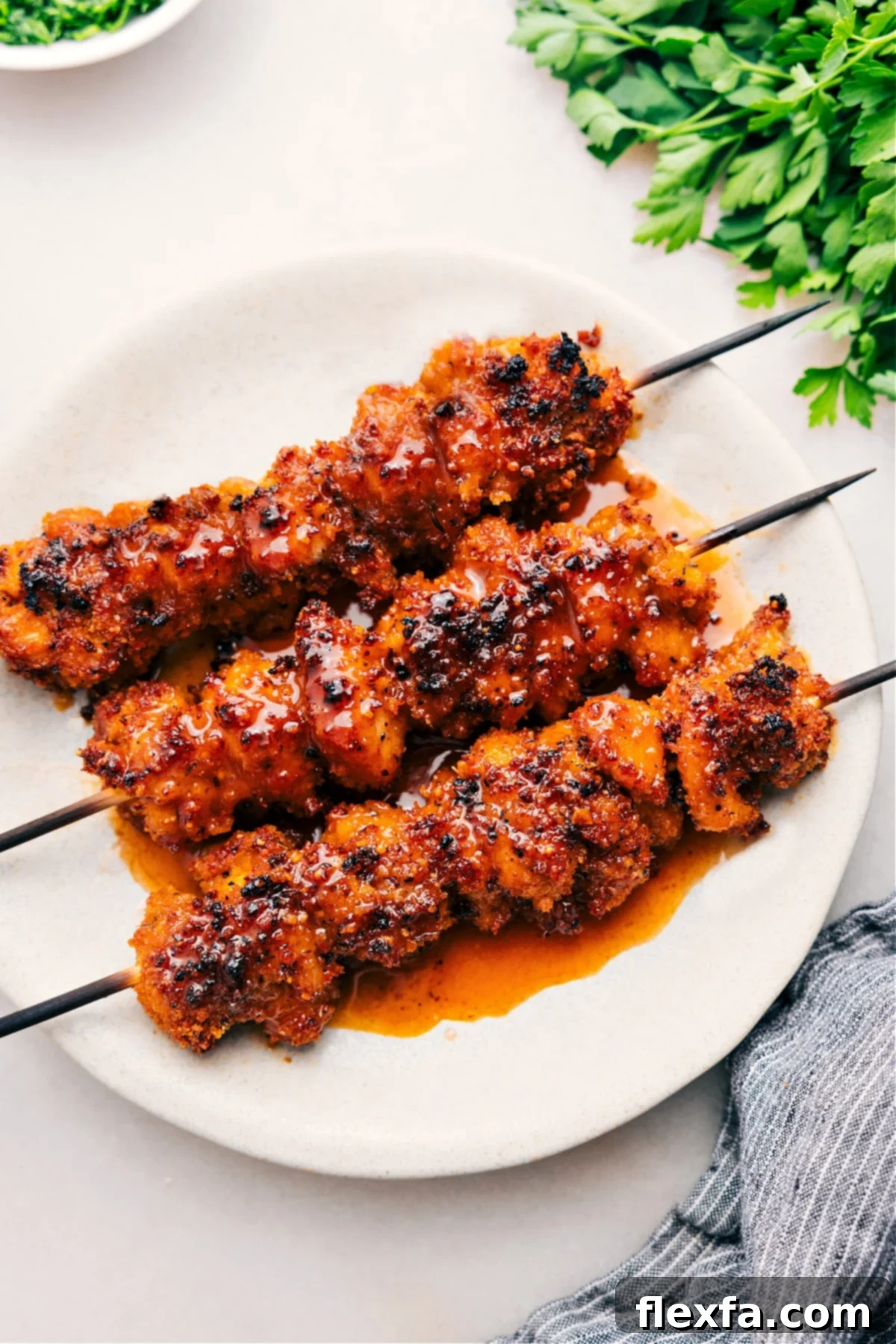 Crispy hot honey chicken skewers, glistening with a spicy-sweet glaze, fresh out of the oven and ready to be enjoyed.