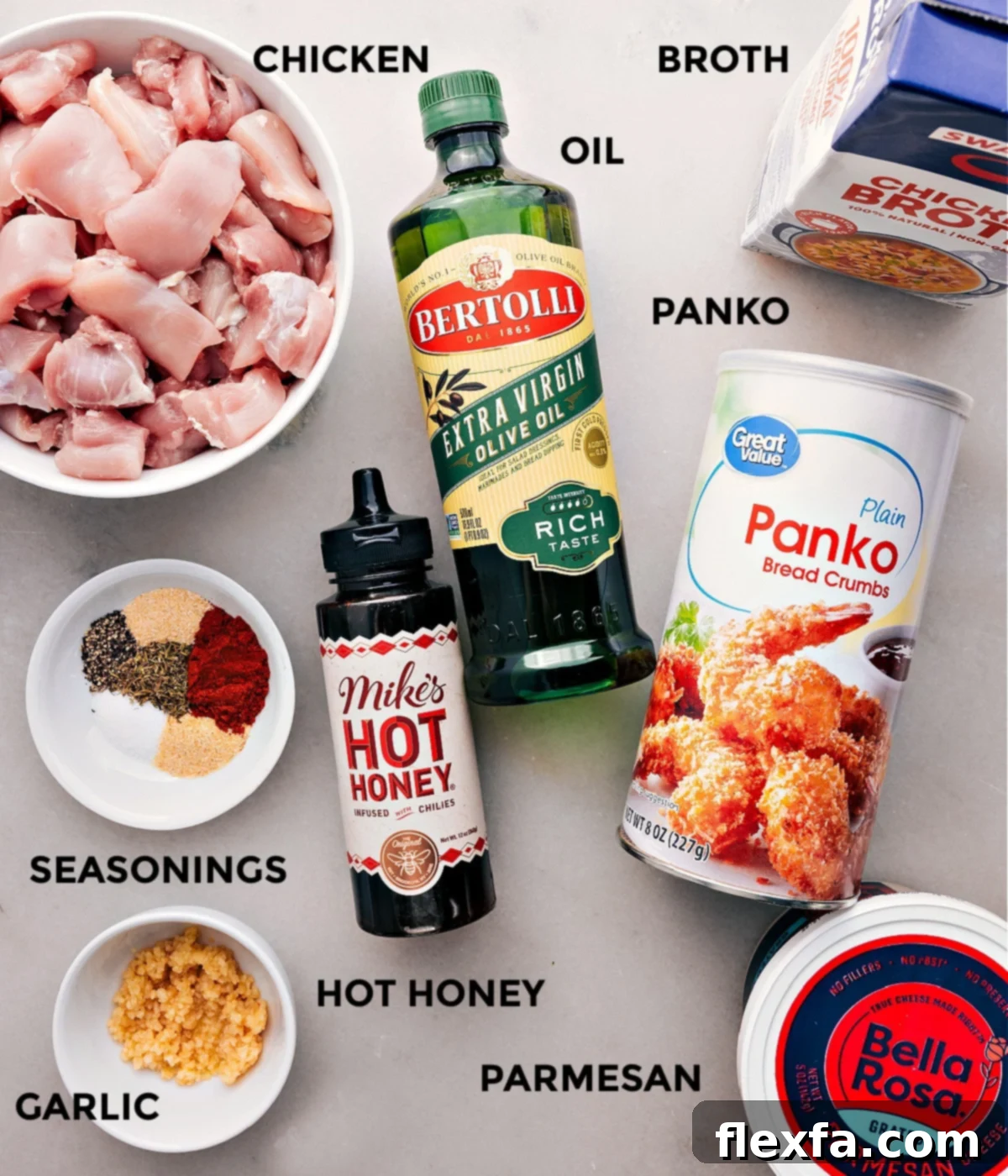 All the fresh ingredients laid out for Hot Honey Chicken: chicken thighs, olive oil, chicken broth, minced garlic, spices, panko breadcrumbs, grated Parmesan, butter, hot honey, and hot sauce.