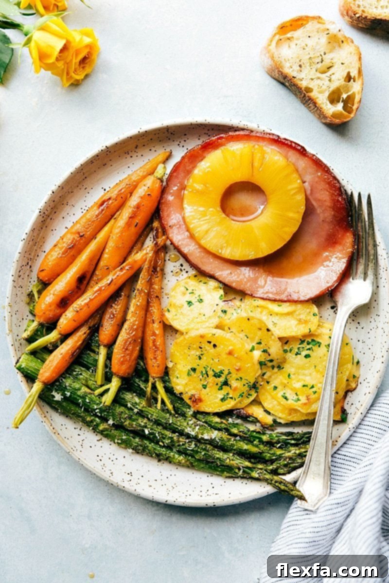 An entire Easter Dinner menu, cooked in an hour on two sheet pans. Quick, easy, and delicious holiday meal ideas. A beautifully plated Easter dinner featuring sliced ham, roasted carrots, creamy au gratin potatoes, and fresh asparagus spears.