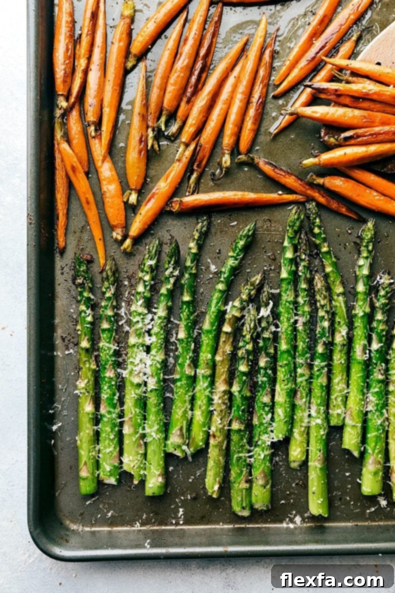 A portion of the two-sheet-pan Easter dinner: roasted carrots and asparagus. Sheet pan with honey-butter carrots and parmesan asparagus, perfectly roasted and ready.