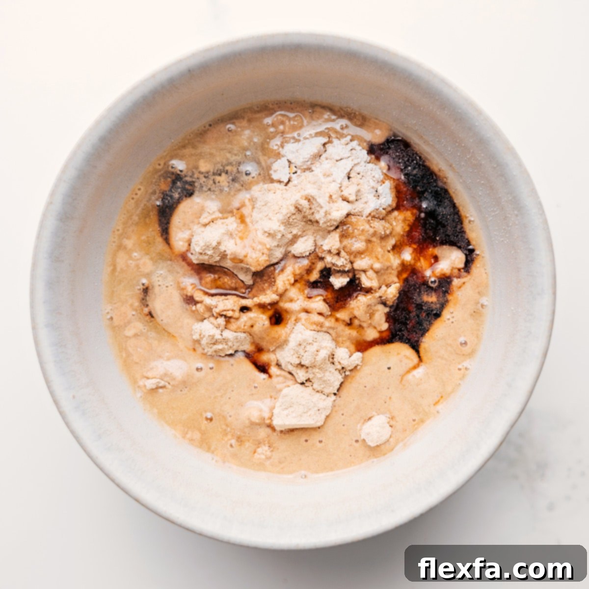 A close-up shot of freshly mixed protein cookie dough in a bowl, with chocolate chips visible, showcasing its perfect texture and readiness to eat.