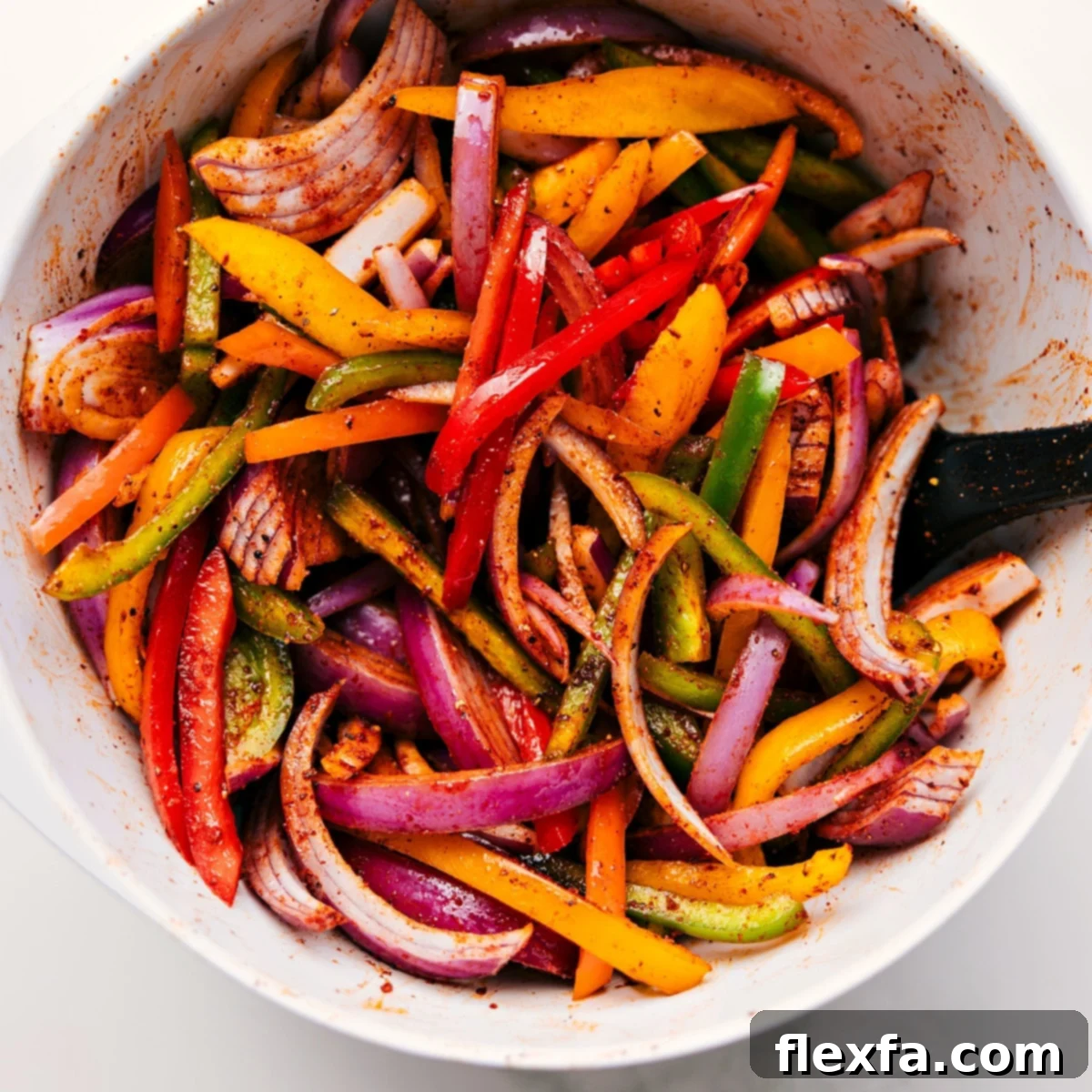 How To Make Sheet Pan Chicken Fajitas All the veggies chopped and tossed with the seasoning mix in a bowl for these sheet pan chicken fajitas.