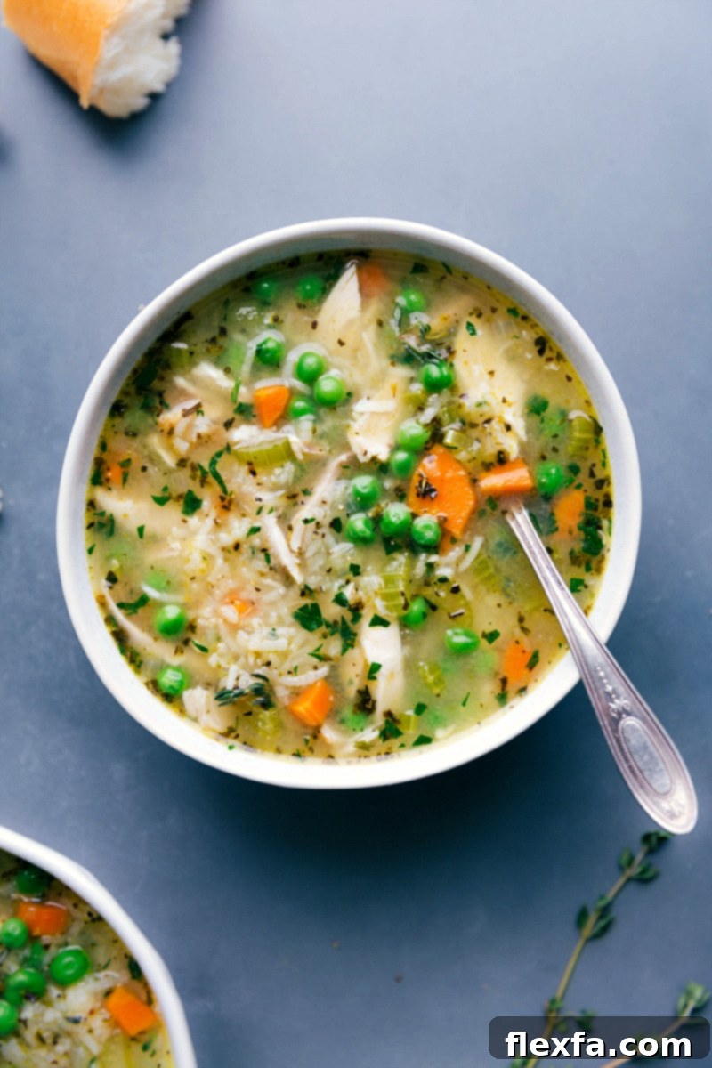Hearty Chicken and Rice Soup: A Warm & Delicious Meal A steaming bowl of homemade chicken and rice soup, garnished with fresh herbs, ready to be enjoyed.