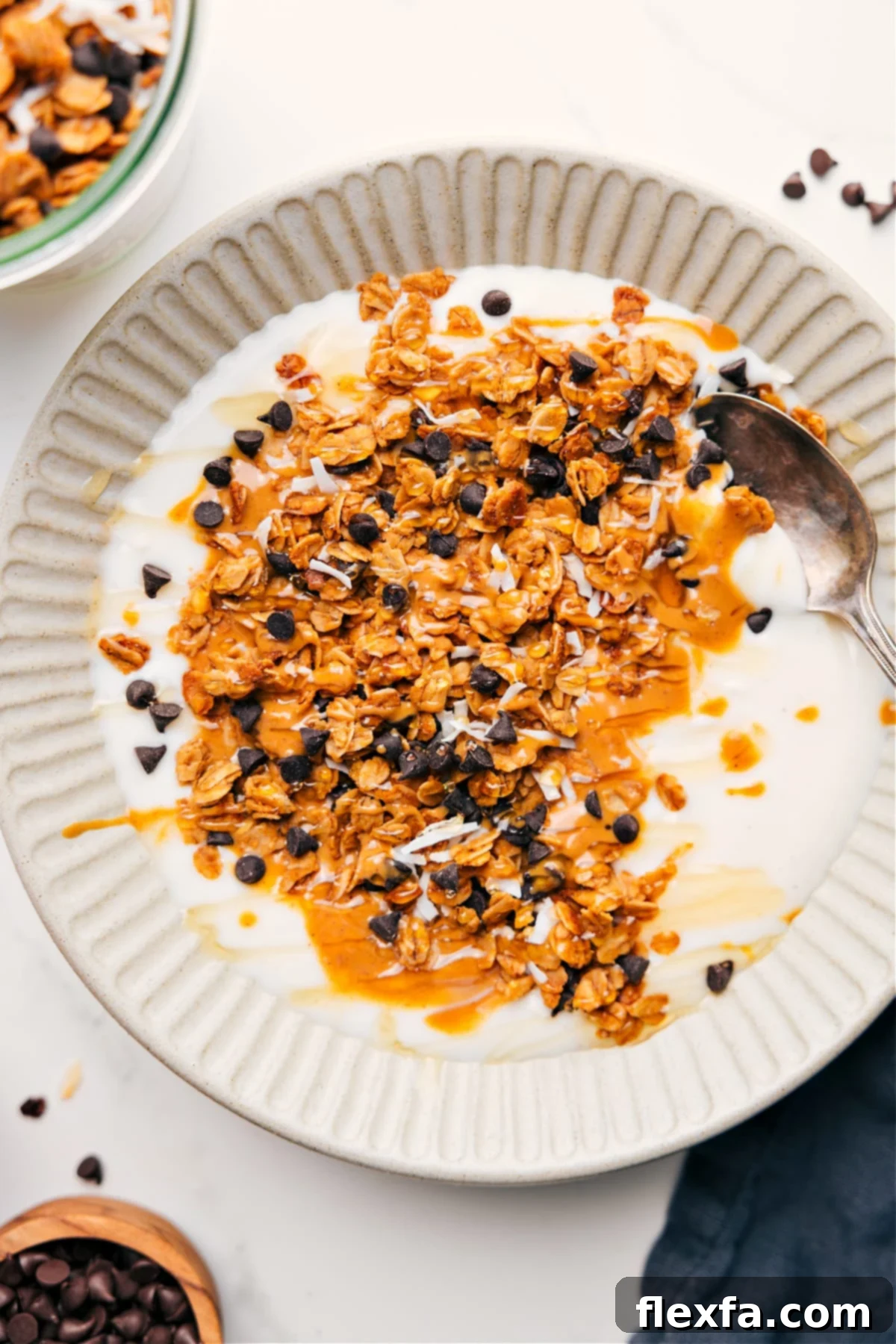 Peanut Butter Granola and Yogurt Bowl Peanut Butter Granola Recipe served over creamy yogurt with a golden drizzle of honey and fresh berries on top.