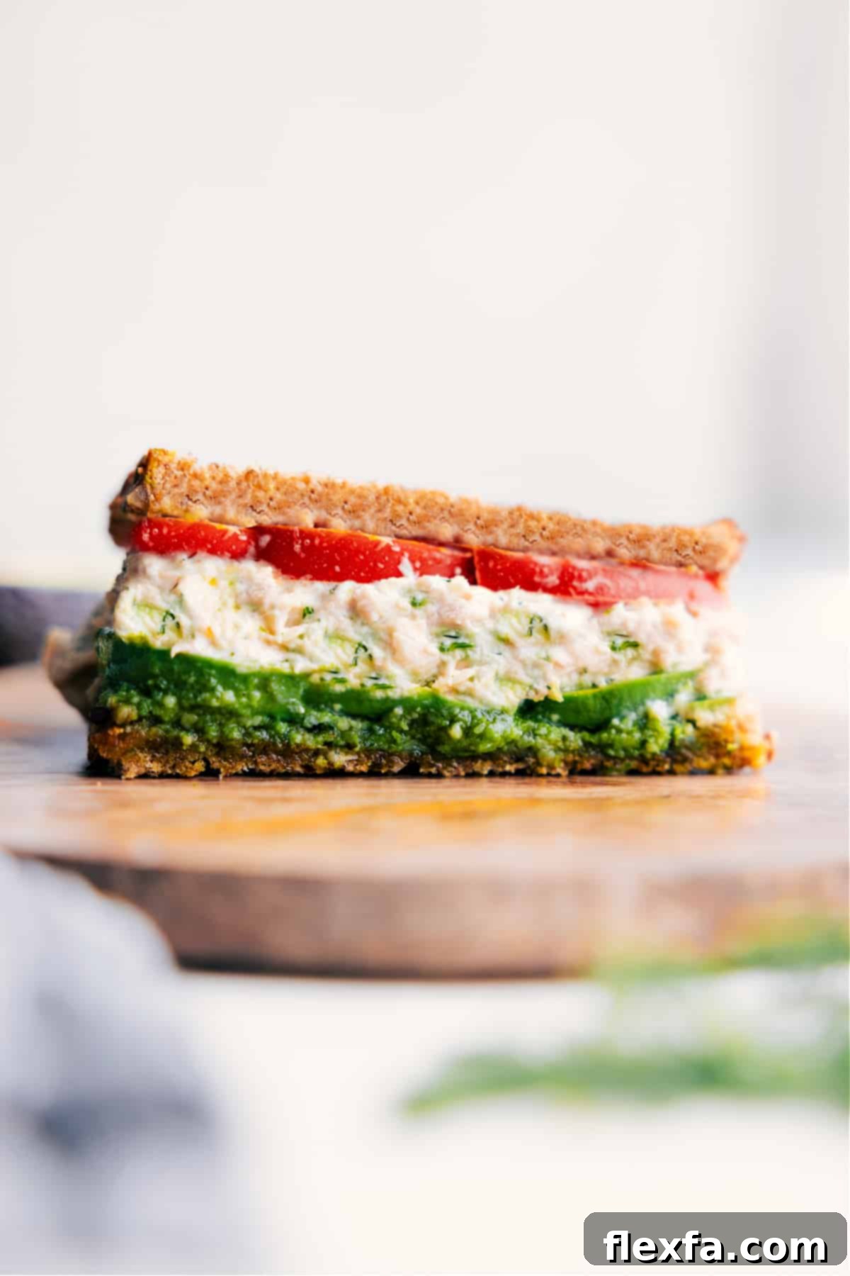 The Viral, Delicious Tunacado Recipe The viral tunacado sandwich fully assembled and ready to eat, sliced in half diagonally, showcasing its vibrant layers.