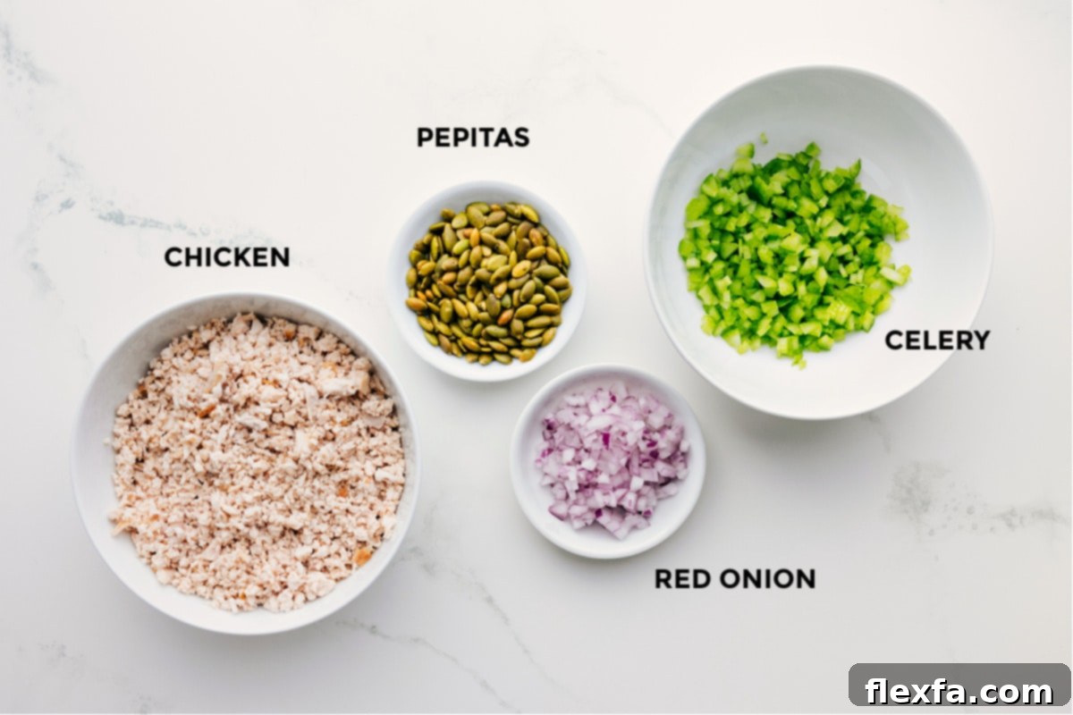 Ingredients In Green Goddess Chicken Salad Prepared ingredients for Green Goddess Chicken Salad: shredded chicken, crunchy pepitas, finely diced celery, and red onion.
