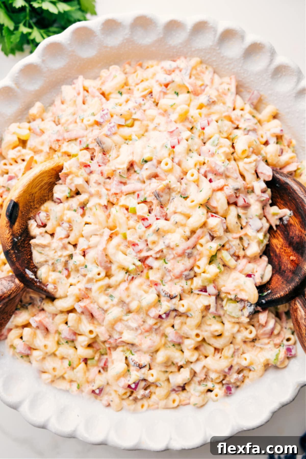 The Yummiest Pasta Salad: Chicken Macaroni Salad - Perfect for Picnics & Potlucks A large bowl filled with a delicious Chicken Macaroni Salad, ready to be served. The pasta is coated in a creamy dressing, with visible pieces of chicken, bacon, carrots, and bell peppers.