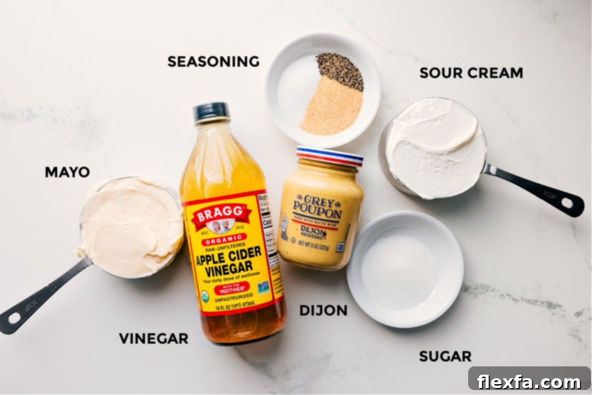 Key Ingredients for the Delicious Dressing Ingredients for the creamy dressing of Chicken Macaroni Salad laid out, including mayonnaise, sour cream, apple cider vinegar, Dijon mustard, granulated sugar, garlic powder, salt, and pepper.