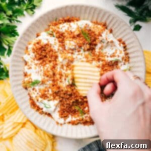 Delicious Fried Pickle Dip in a serving bowl, garnished and ready with potato chips for dipping.