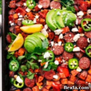 A close-up of the finished Sheet Pan Hot Honey Sausage & Veggies, showcasing the glazed sausage, tender, caramelized vegetables, and vibrant toppings, ready to be served.