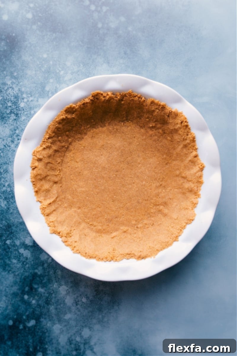 The Ultimate Graham Cracker Pie Crust – perfectly sweet, buttery, and sturdy with the ideal ratio. Get all the tips for a flawless homemade crust! #dessert #best #quick #easy #simple #pie #thanksgiving #graham #cracker #crust Overhead image of a perfectly baked golden brown Graham Cracker Crust in a pie pan, ready for filling.