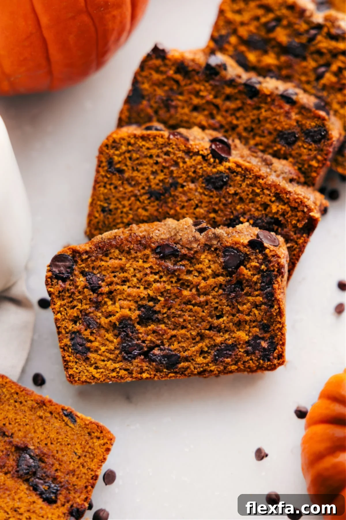 Thick, moist slices of healthy pumpkin bread generously studded with chocolate chips, perfect for a wholesome fall treat.