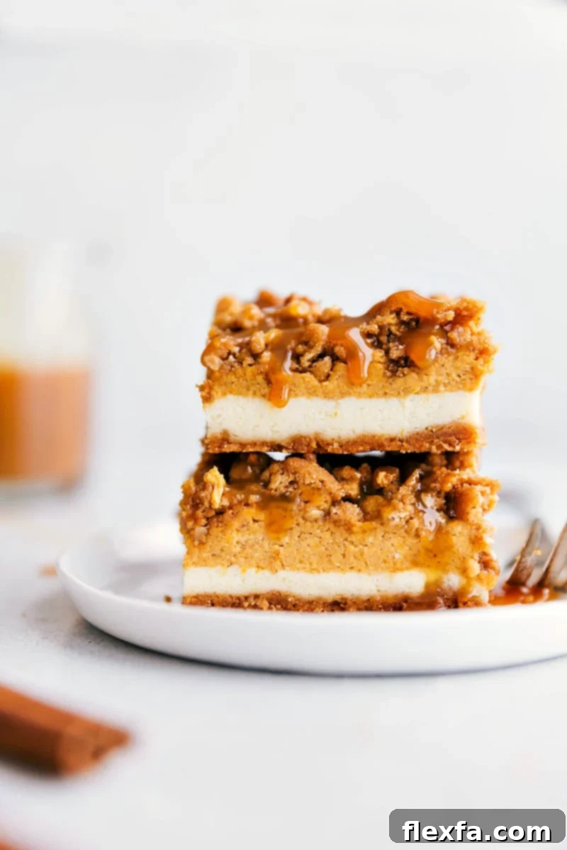 Stacked pumpkin cheesecake bars, richly drizzled with luscious caramel, epitomizing the perfect pumpkin spice dessert for fall gatherings.
