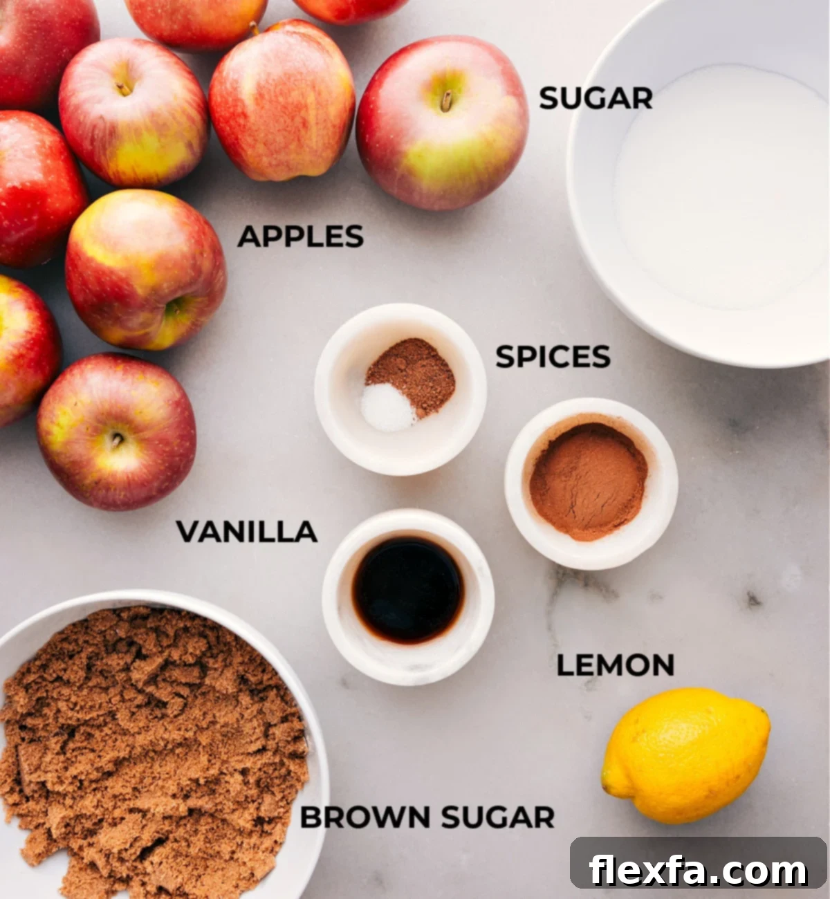 Assorted ingredients for Crockpot Apple Butter spread out, including fresh sweet apples, brown sugar, white sugar, ground cinnamon, nutmeg, vanilla extract, and lemon juice.
