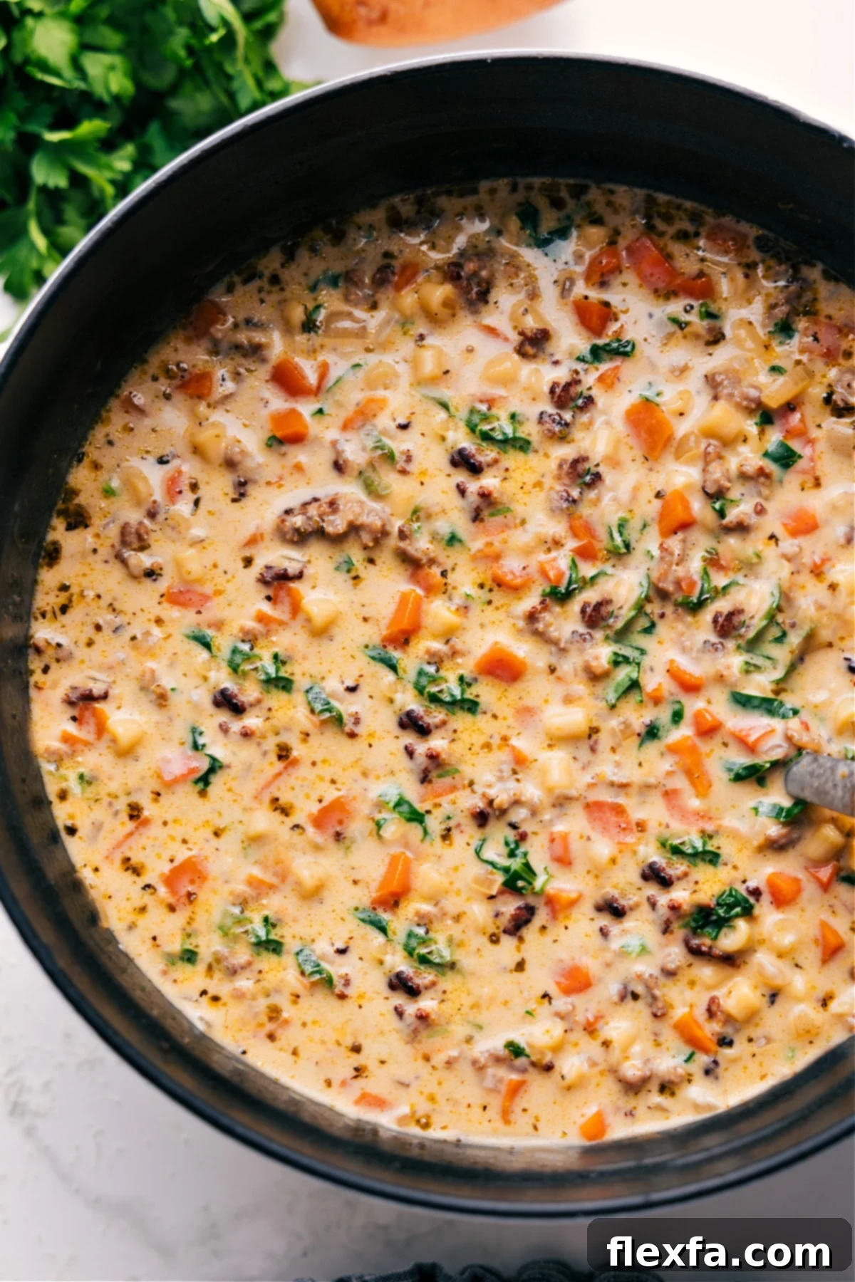 One Pot Creamy Parmesan Italian Sausage Soup A large pot filled with rich, creamy Parmesan Italian Sausage Soup, brimming with pasta and sausage, ready to be served.