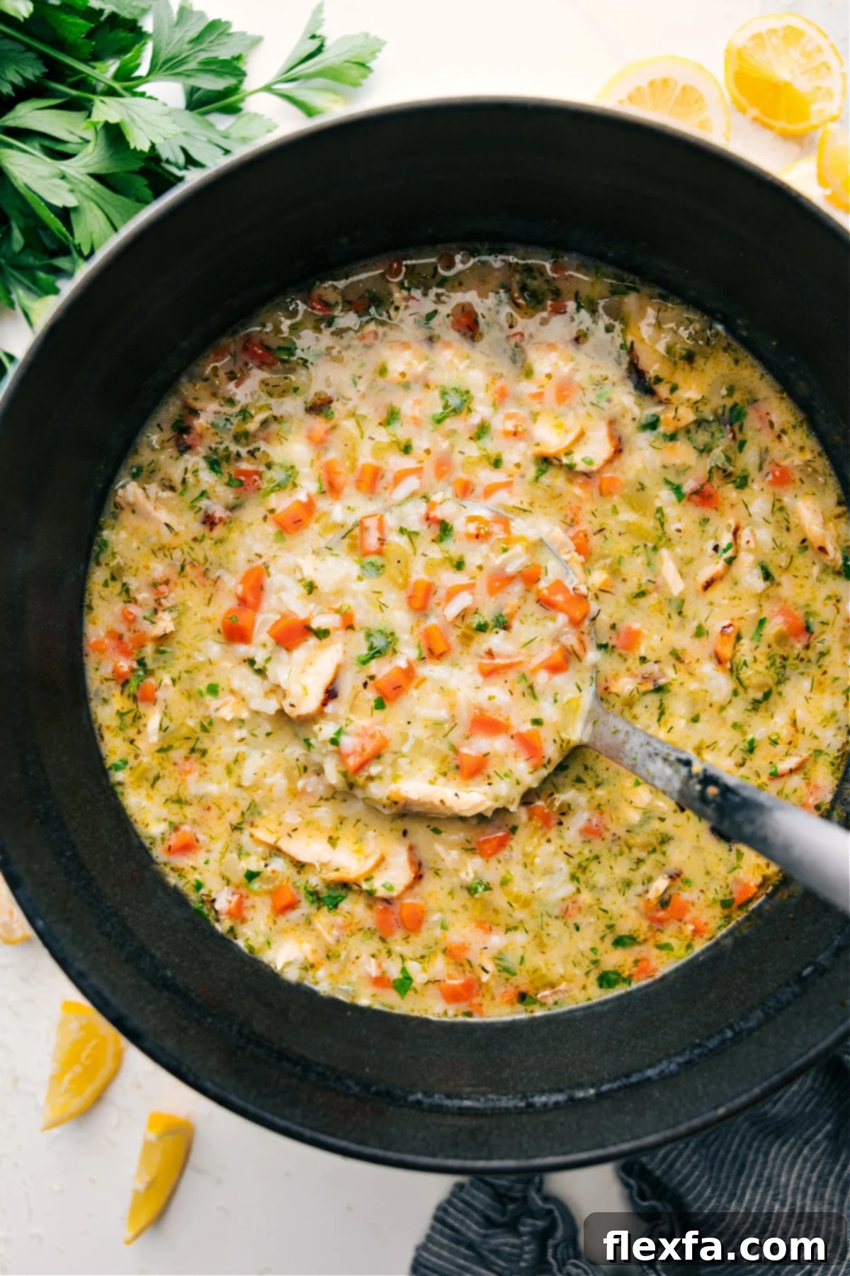 A large pot filled with steaming Greek Lemon Soup, garnished with fresh dill, ready to be served.