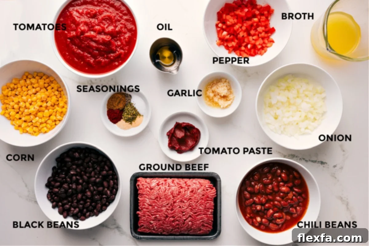 All the fresh and pantry ingredients for this cornbread casserole recipe laid out, including vibrant corn, black beans, tomatoes, an array of seasonings, olive oil, ground beef, garlic, colorful bell peppers, onions, chili beans, and chicken broth.